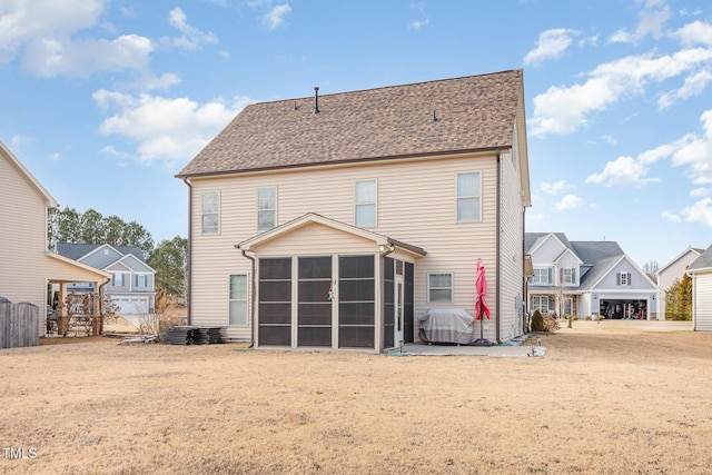 rear view of house featuring a yard and a sunroom