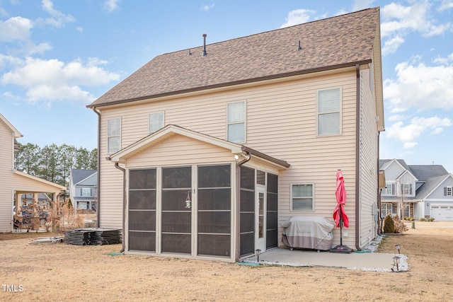 rear view of property with a sunroom, a lawn, and a patio area