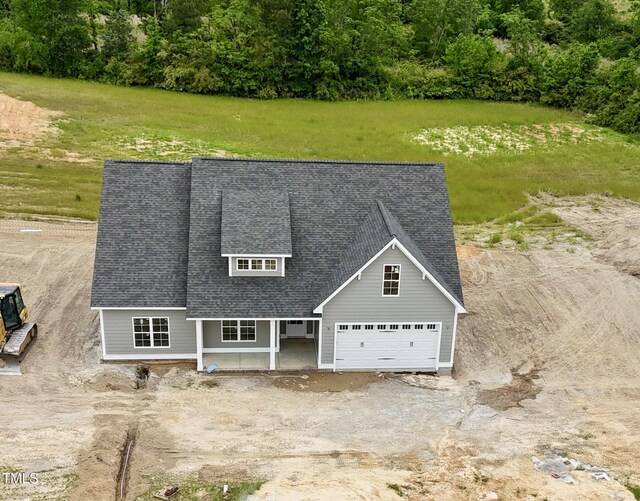 view of front facade featuring roof with shingles and a garage