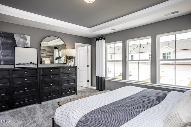 bedroom with light carpet, a tray ceiling, and crown molding