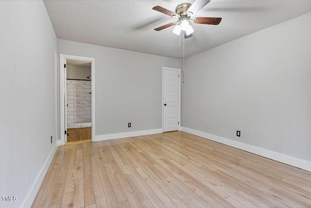 empty room with light wood-style flooring, a textured ceiling, baseboards, and a ceiling fan