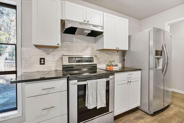 kitchen with decorative backsplash, dark countertops, appliances with stainless steel finishes, and under cabinet range hood