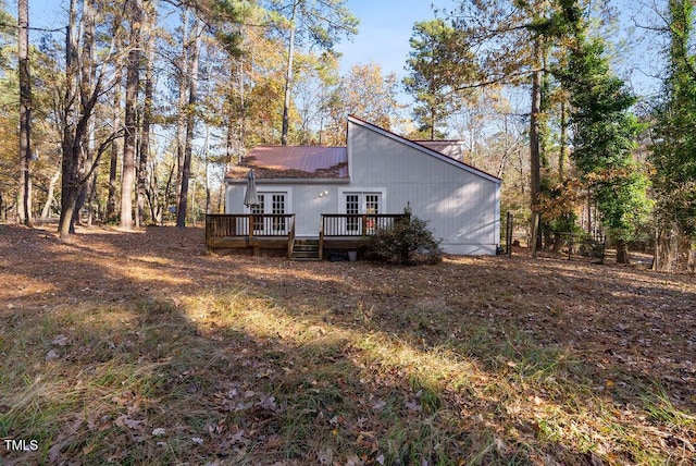 rear view of property featuring a deck and french doors