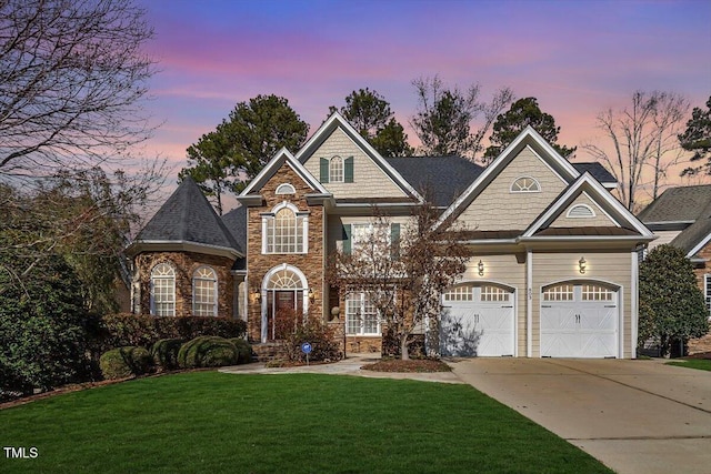 view of front facade with a garage, concrete driveway, and a lawn