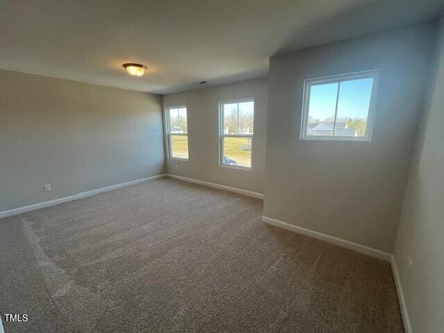 carpeted spare room with baseboards