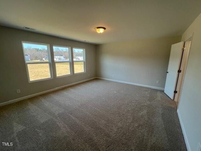 unfurnished room featuring carpet, visible vents, and baseboards