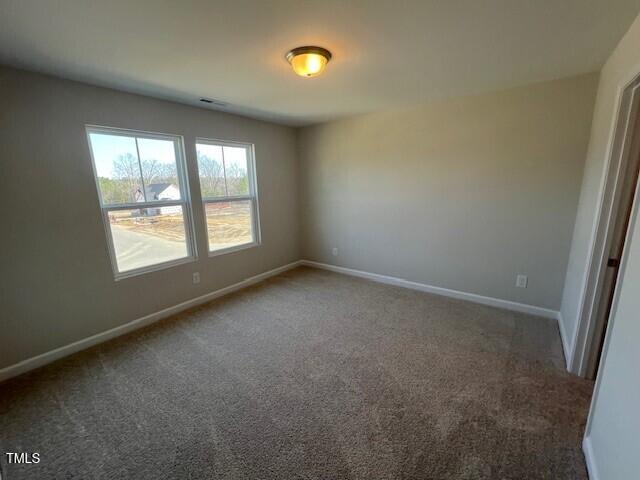 unfurnished room featuring carpet and baseboards