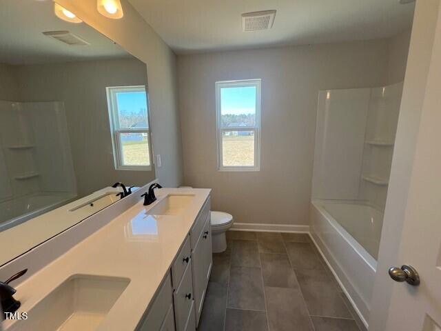 bathroom with baseboards, visible vents, and a sink