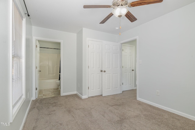 unfurnished bedroom with light carpet, connected bathroom, a closet, and ceiling fan