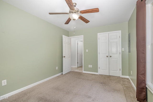 unfurnished bedroom with ceiling fan, light colored carpet, and a closet