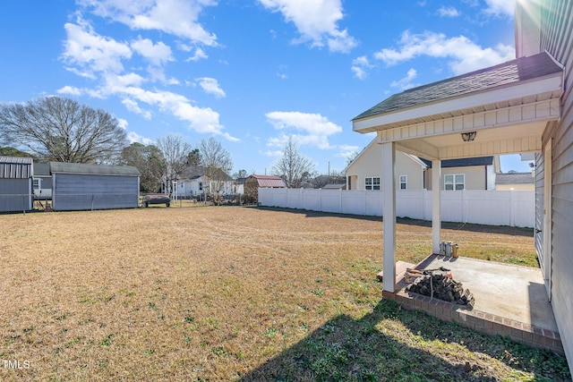 view of yard with a storage shed and a patio