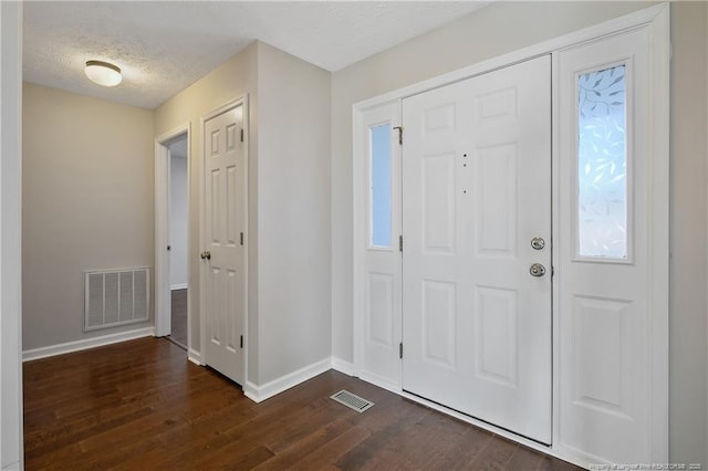 foyer entrance featuring dark hardwood / wood-style floors and a textured ceiling