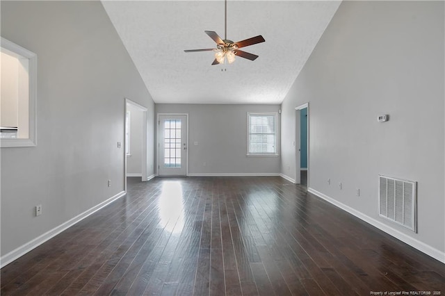 interior space with dark hardwood / wood-style flooring, a textured ceiling, lofted ceiling, and ceiling fan