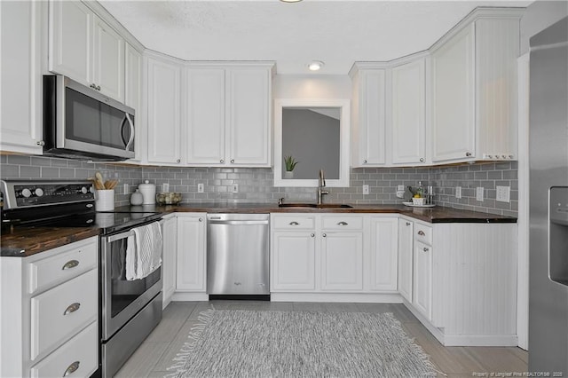 kitchen featuring white cabinetry, sink, tasteful backsplash, and appliances with stainless steel finishes