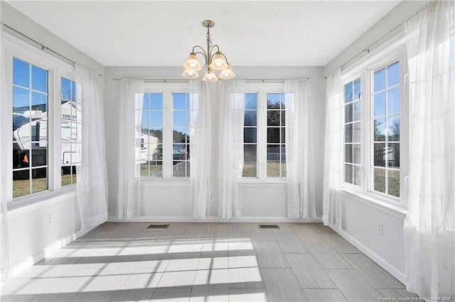 unfurnished sunroom with a chandelier and a wealth of natural light