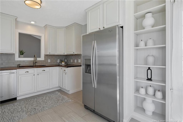 kitchen with white cabinetry, sink, tasteful backsplash, and stainless steel appliances