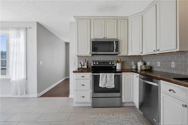 kitchen with stainless steel appliances, tasteful backsplash, a healthy amount of sunlight, and white cabinets