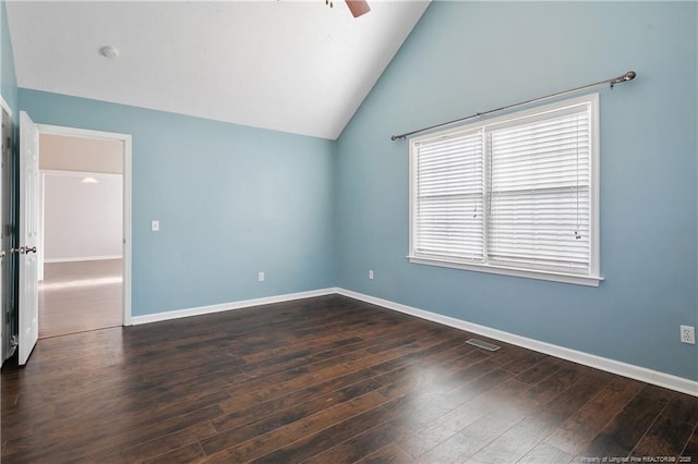 empty room featuring vaulted ceiling, dark hardwood / wood-style floors, and ceiling fan