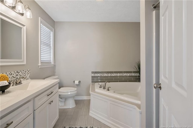 bathroom featuring vanity, a textured ceiling, a tub to relax in, decorative backsplash, and toilet