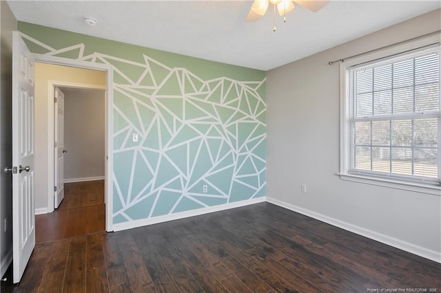 empty room with ceiling fan, a healthy amount of sunlight, and dark hardwood / wood-style floors