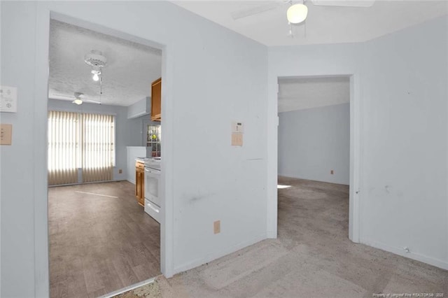 kitchen featuring ceiling fan, light hardwood / wood-style floors, a textured ceiling, and white range oven