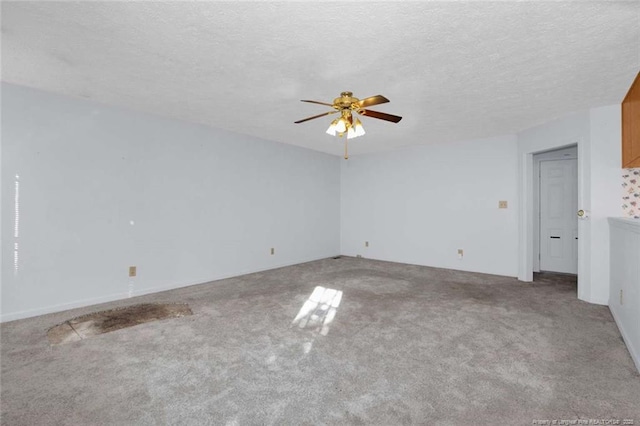 carpeted spare room featuring ceiling fan and a textured ceiling