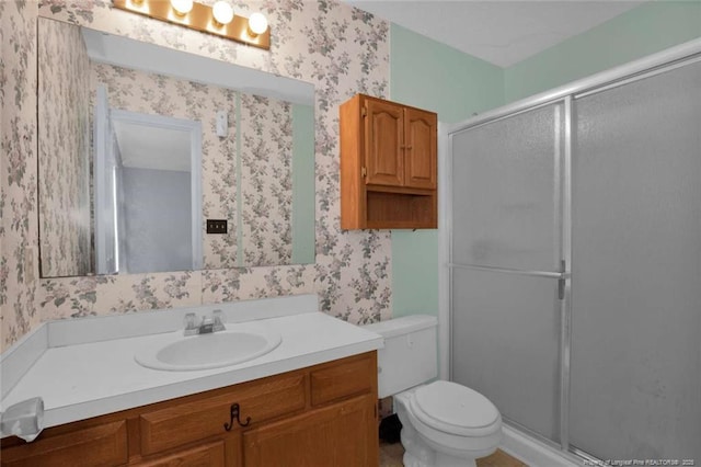 bathroom featuring walk in shower, vanity, and toilet