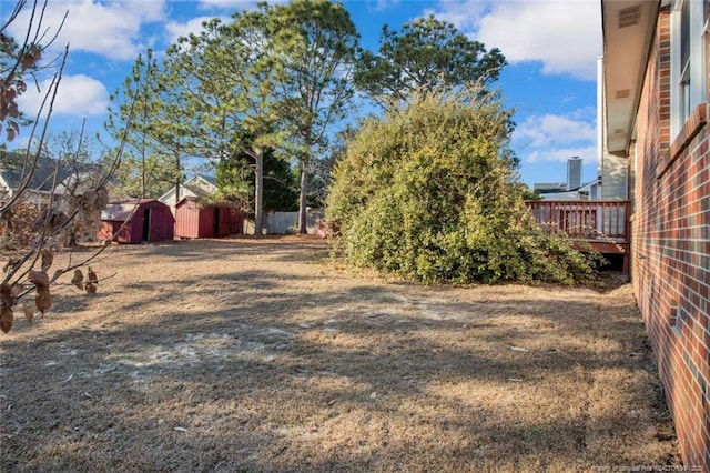 view of yard with a deck and a shed