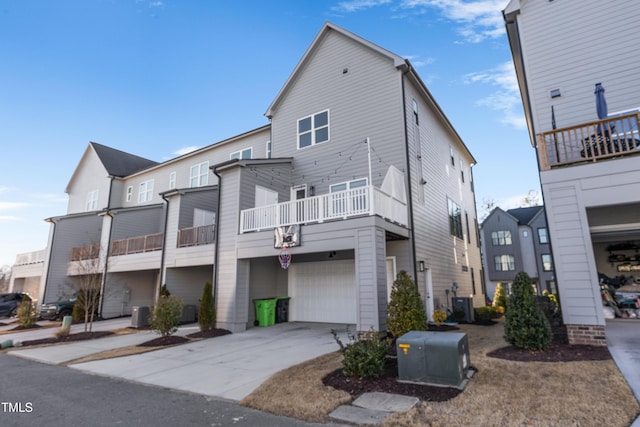 back of house featuring a garage, a balcony, and central AC unit