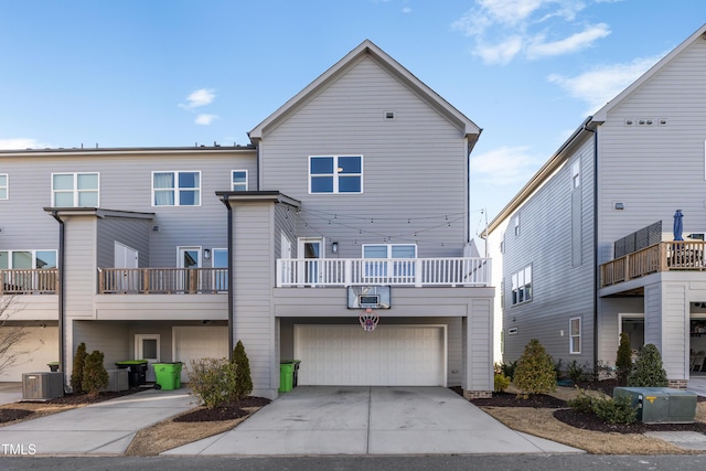 back of property with a garage, a balcony, and central air condition unit