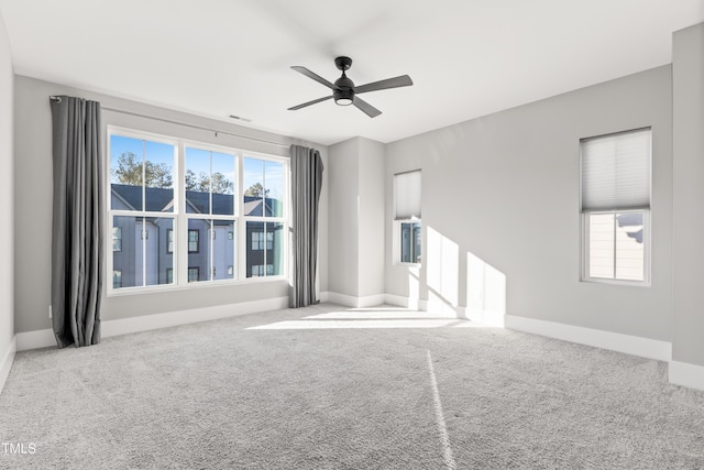 carpeted empty room featuring ceiling fan and a healthy amount of sunlight