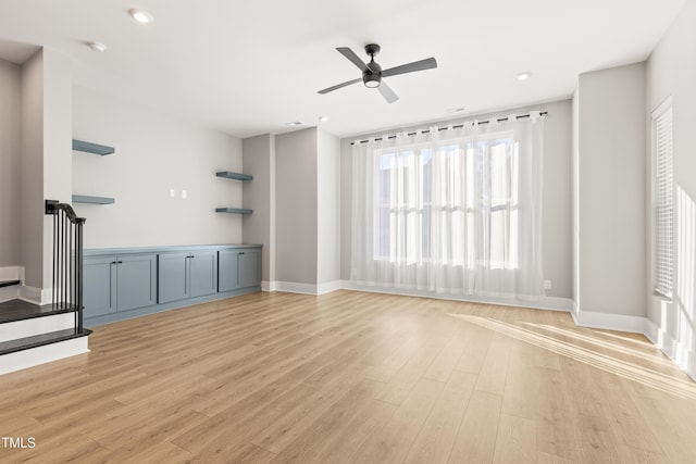 unfurnished living room featuring ceiling fan and light hardwood / wood-style flooring