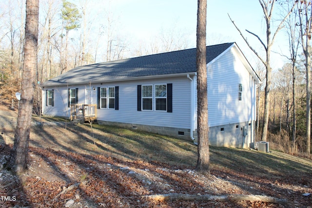 single story home featuring crawl space, cooling unit, a front yard, and a shingled roof