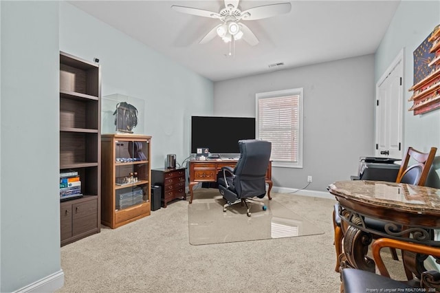 carpeted office space featuring ceiling fan