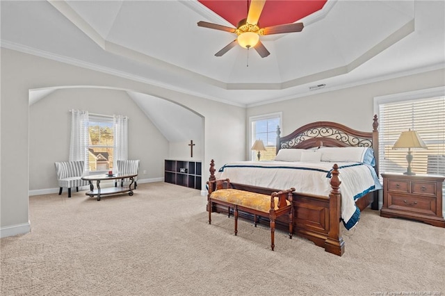 carpeted bedroom featuring ceiling fan, ornamental molding, and a tray ceiling