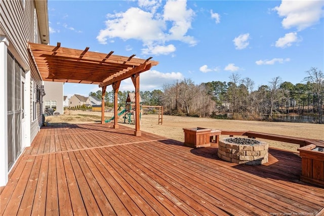 wooden terrace featuring a pergola, a playground, and an outdoor fire pit