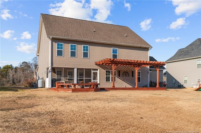 rear view of property with a yard, a deck, and a pergola