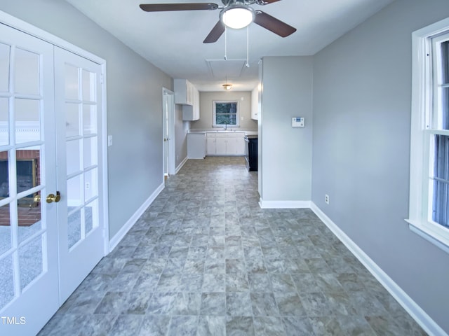 interior space with ceiling fan, plenty of natural light, and sink