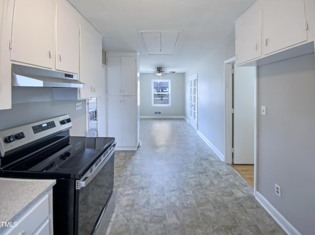 kitchen with stainless steel electric range and white cabinets