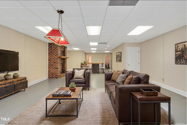 living room with a paneled ceiling and concrete flooring