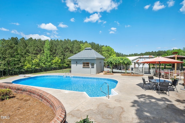 view of pool featuring a gazebo, an outdoor structure, a diving board, and a patio area