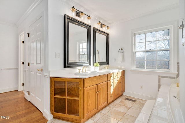 bathroom with crown molding, vanity, and a bathtub