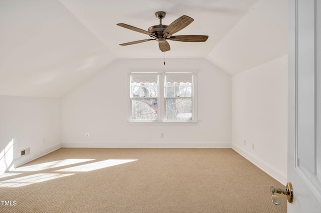 additional living space with ceiling fan, light colored carpet, and vaulted ceiling