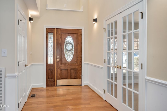 entrance foyer with french doors and light hardwood / wood-style flooring