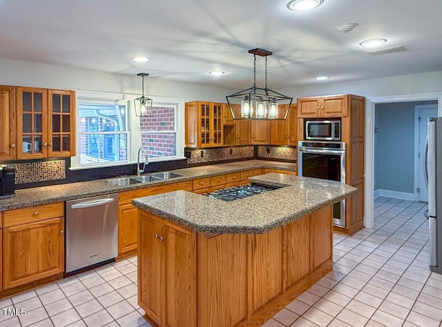 kitchen with stainless steel appliances, a kitchen island, sink, and decorative light fixtures