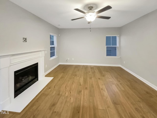 unfurnished living room featuring ceiling fan and light hardwood / wood-style floors