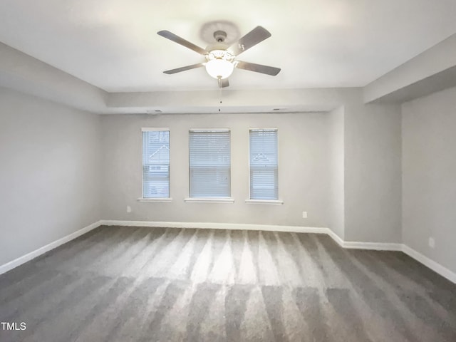 unfurnished room featuring ceiling fan and dark carpet