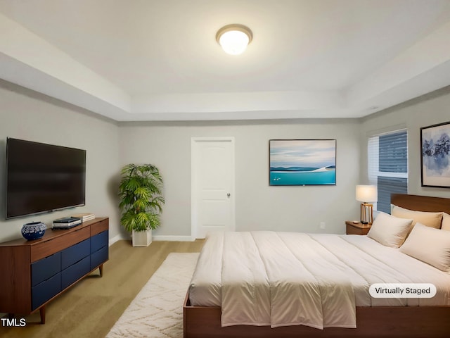 carpeted bedroom with a raised ceiling