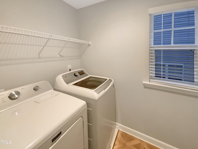 laundry area with parquet flooring and washing machine and dryer