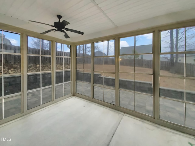 unfurnished sunroom with ceiling fan